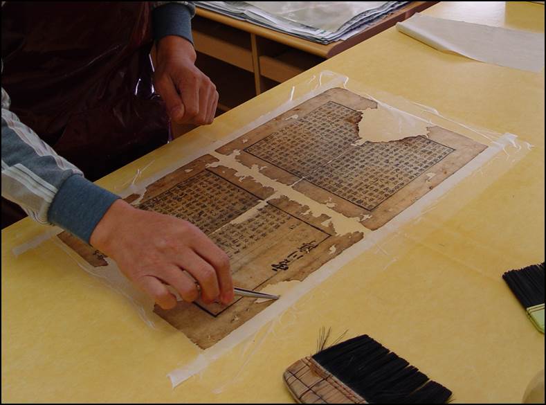 천공이나 훼손된 부분을 보충지를 대어서 보강해주는 사진