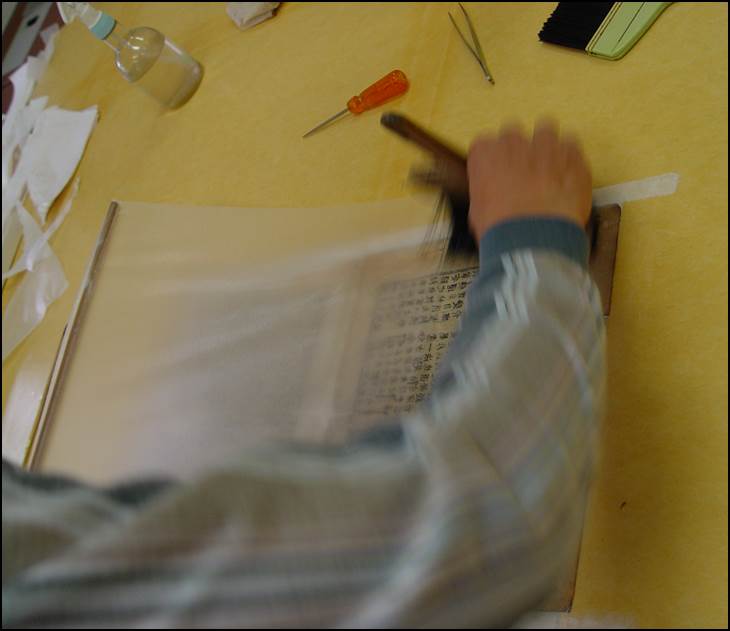 배접지를 작업대에 올리고 묽은 풀로 전면을 풀칠하는 사진