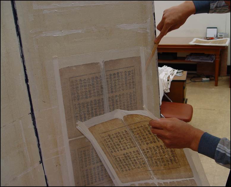 건조된 책지를 헤라를 이용하여 한장씩 떼어내는 사진